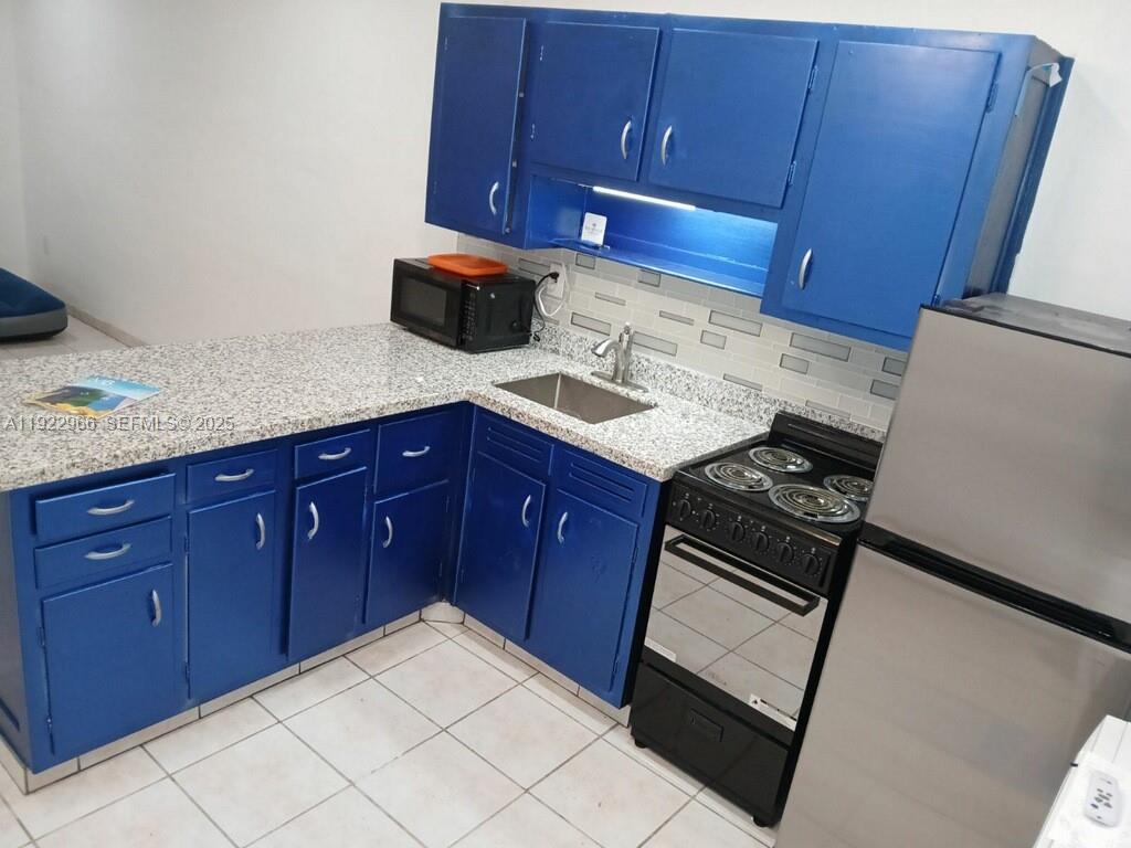 7300 Byron Avenue, Unit 8 Miami Beach, FL 33141 - Photo 7 of 9 a kitchen with a stove microwave and sink