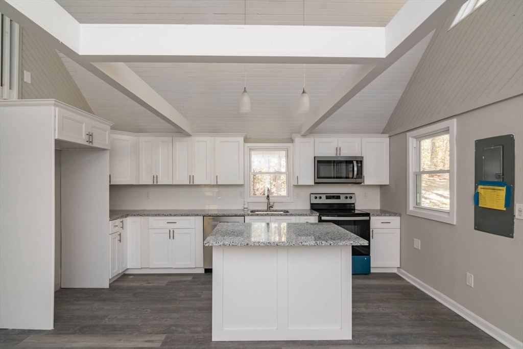 56 Ball Road Goshen, MA 01096 - Photo 16 of 33 a kitchen with stainless steel appliances granite countertop a stove top oven a sink dishwasher and a refrigerator with wooden floor