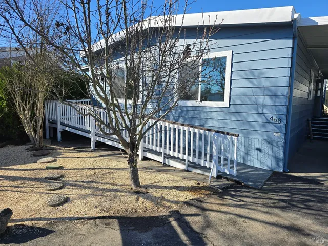 a front view of a house with a tree