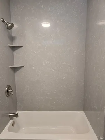 en empty room with windows and ceiling fan