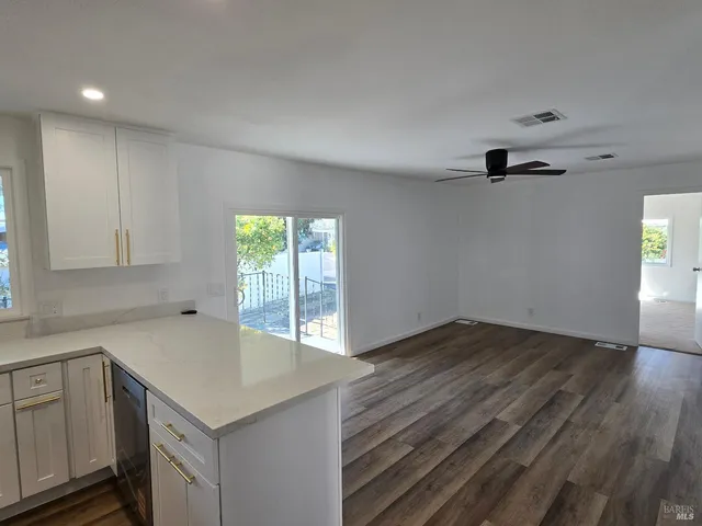 a kitchen with stainless steel appliances a refrigerator sink and wooden floor