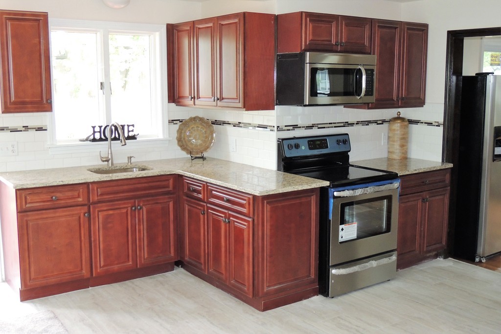 29 Dwight Road Springfield, MA 01108 - Photo 4 of 25 a kitchen with stainless steel appliances granite countertop a stove microwave and refrigerator