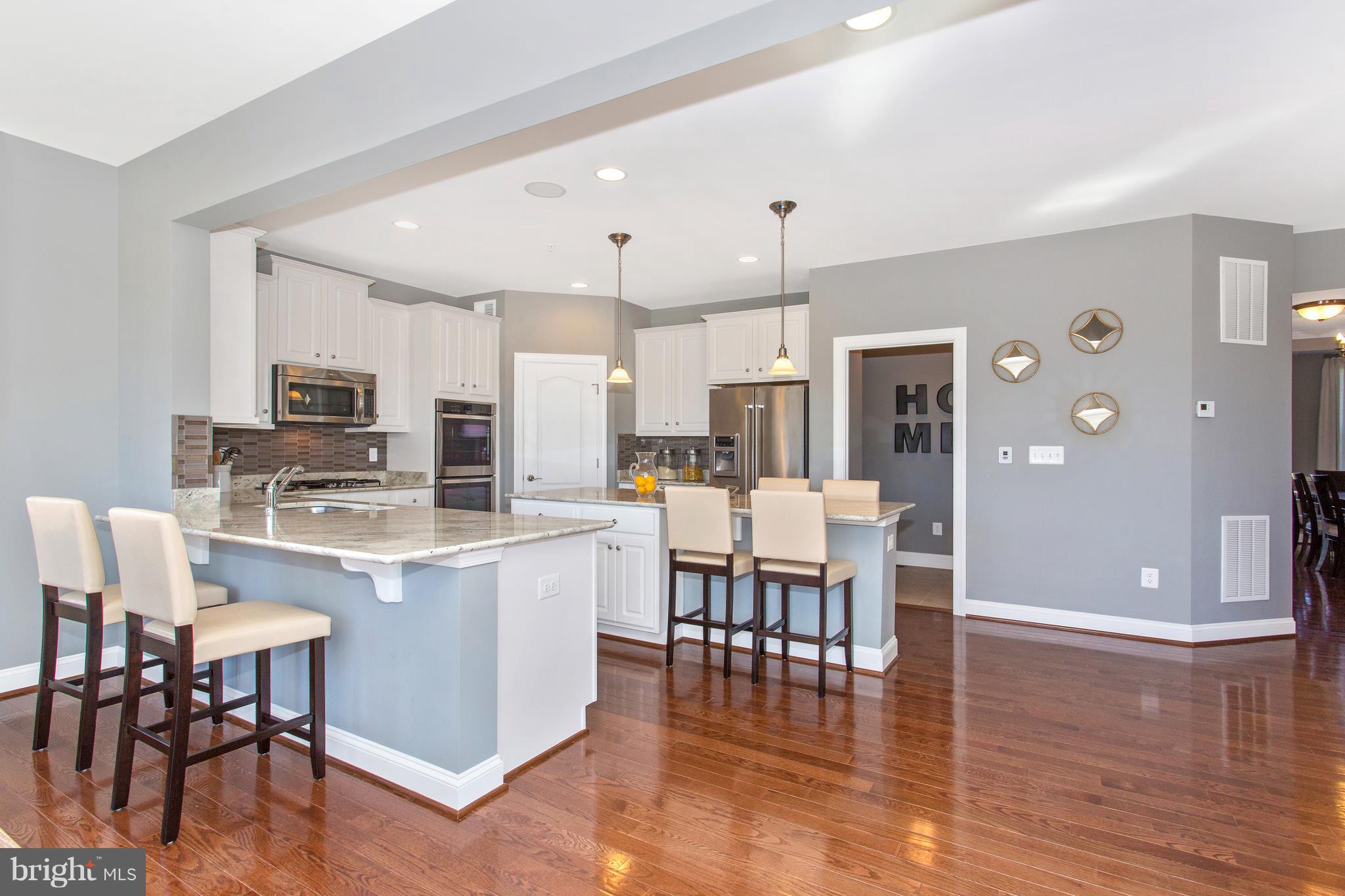 2112 Gable Drive Jessup, MD 20794 - Photo 16 of 27 a kitchen with stainless steel appliances kitchen island granite countertop a dining table chairs and granite counter tops