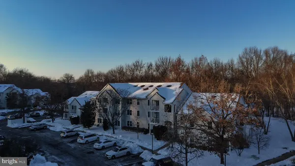 a view of a town with barn and large trees