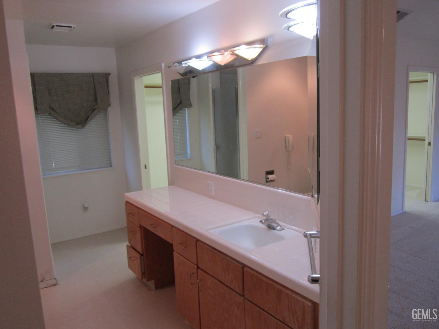 Undisclosed Address Bakersfield, CA 93314 - Photo 8 of 34 a bathroom with a sink a light fixture and a mirror
