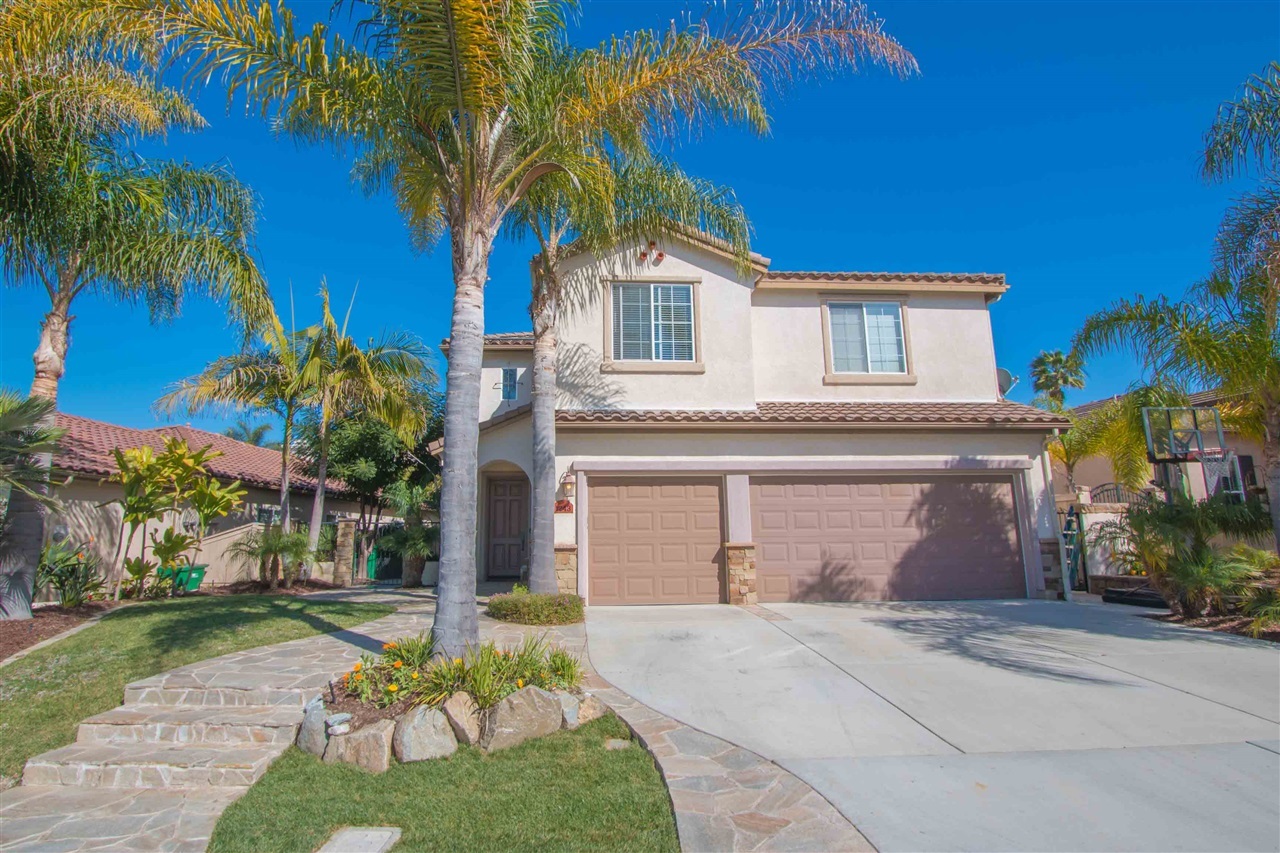 1243 Mariposa Road Carlsbad, CA 92011 - Photo 2 of 25 The beautiful exterior boasts mature tropical foliage and stone hardscape.