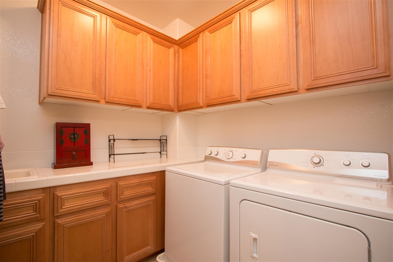 1243 Mariposa Road Carlsbad, CA 92011 - Photo 20 of 25 The spacious laundry room has upper and lower storage cabinets, plenty of counter space and a large sink.
