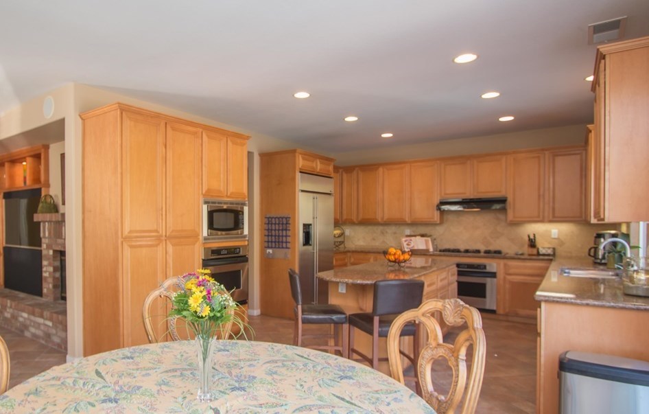1243 Mariposa Road Carlsbad, CA 92011 - Photo 4 of 25 Chef's kitchen has cabinets galore, granite counters with coved edges, GE Profile stainless appliances with two ovens, and built-in GE Monogram refrigerator.