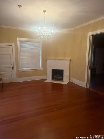 a view of empty room with wooden floor and fireplace