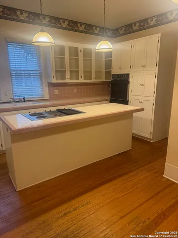 a view of a kitchen with wooden floor and a sink