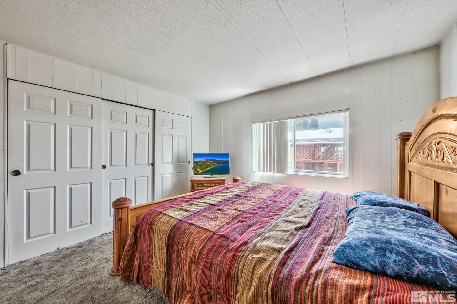 167 Crescent Drive Stateline, NV 89449 - Photo 13 of 23 a bedroom with a bed a table and a window