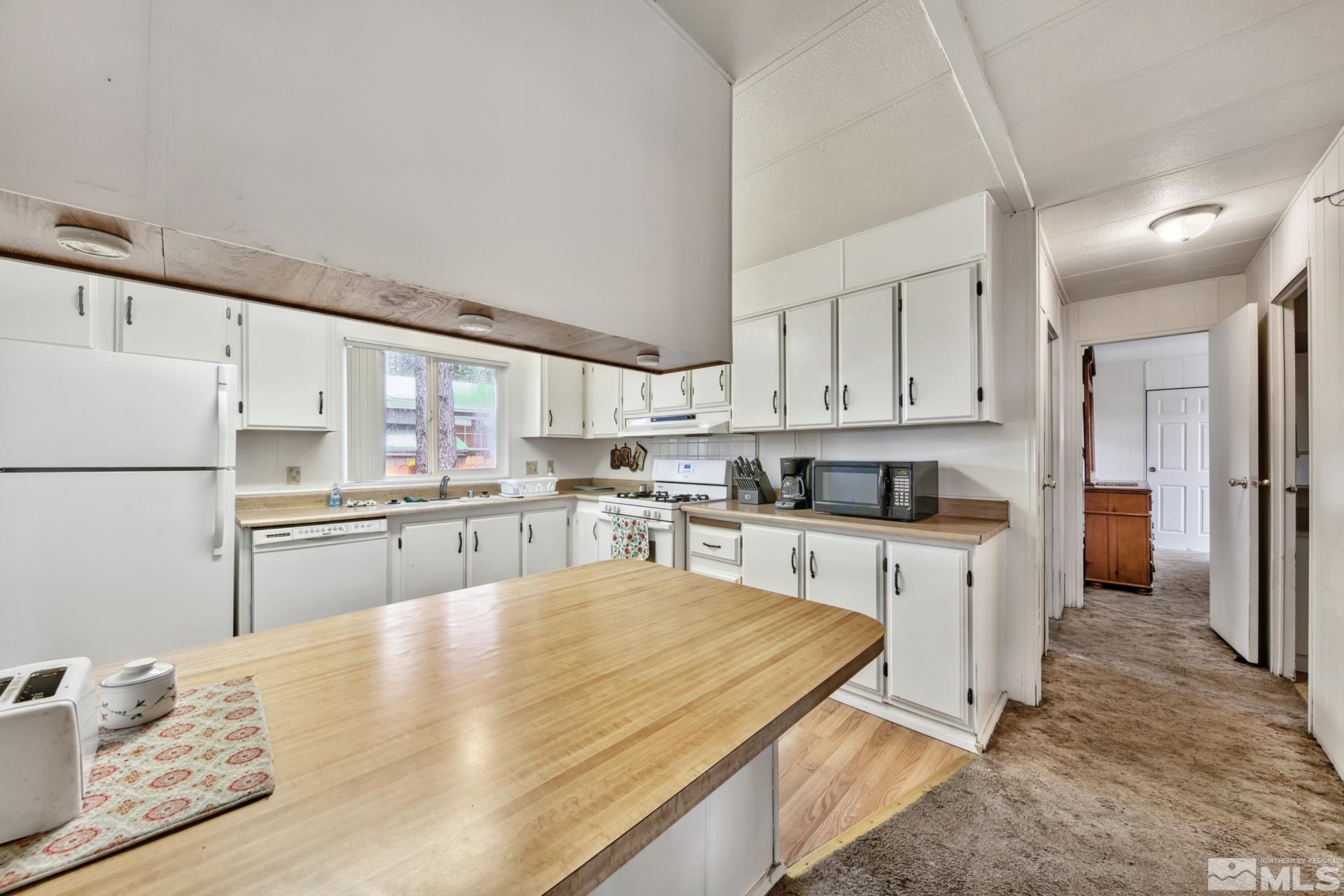 167 Crescent Drive Stateline, NV 89449 - Photo 6 of 23 a kitchen with white cabinets and stainless steel appliances