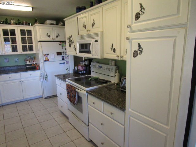 80452 Alston Mayger Road Clatskanie, OR 97016 - Photo 19 of 28 a kitchen with stainless steel appliances granite countertop white cabinets and window