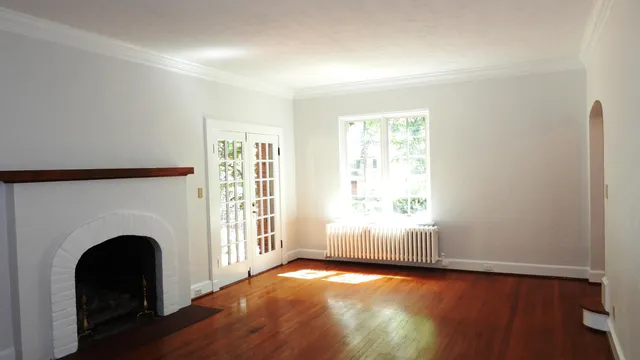 an empty room with windows fire place and a fireplace