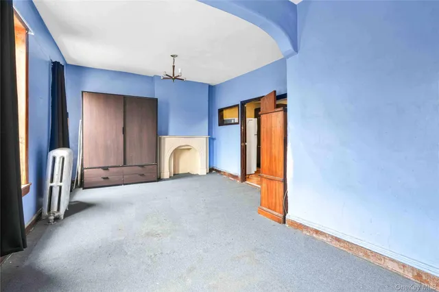 a view of an empty room with a fireplace and a window