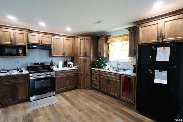 a kitchen with stainless steel appliances granite countertop a stove a sink and a microwave