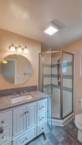 a bathroom with a granite countertop sink mirror and toilet