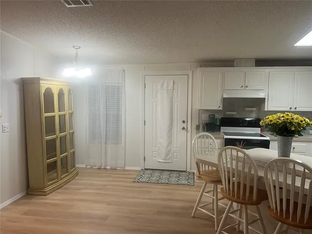 a kitchen with stainless steel appliances a dining table chairs and granite counter tops