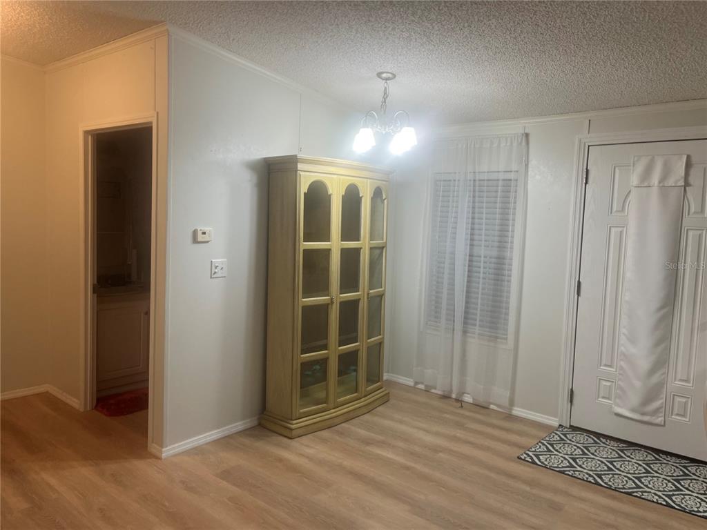 4064 Southwest 9th Way Okeechobee, FL 34974 - Photo 7 of 16 a view of empty room with wooden floor and fan