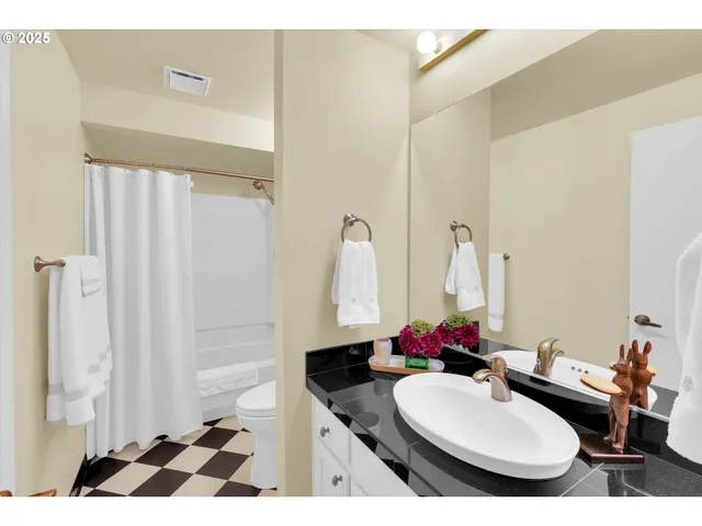 a bathroom with a sink vanity mirror and tub