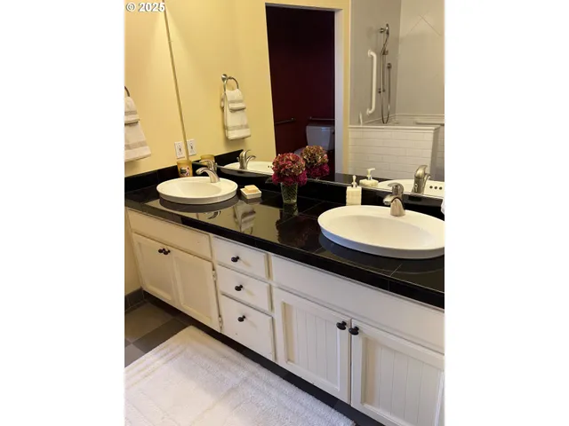 a bathroom with a double vanity sink and a mirror
