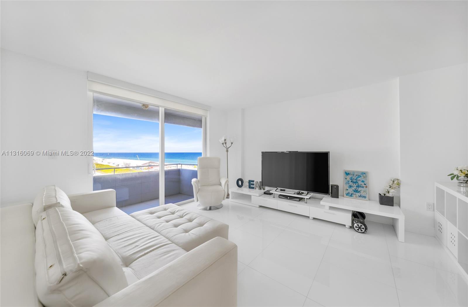 465 Ocean Drive, Unit 1124 Miami Beach, FL 33139 - Photo 1 of 32 a living room with furniture and a flat screen tv