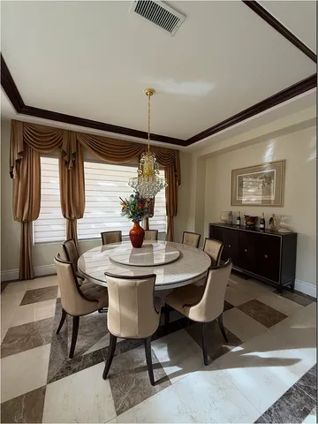 a view of a dining room with furniture and chandelier