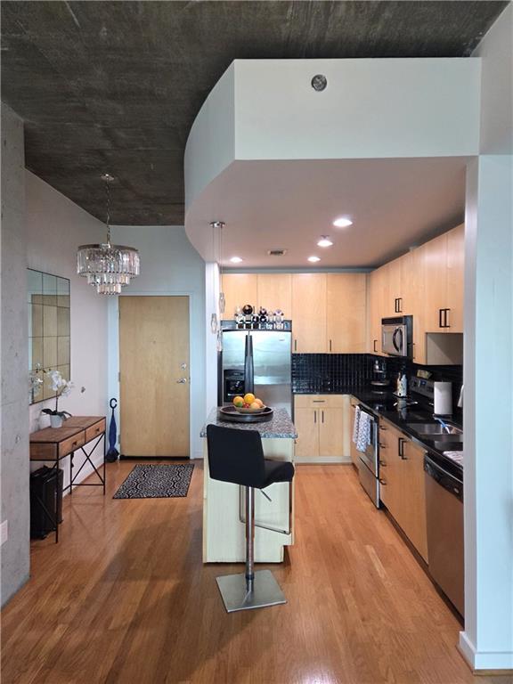 a kitchen with stainless steel appliances kitchen island a refrigerator and a stove top oven