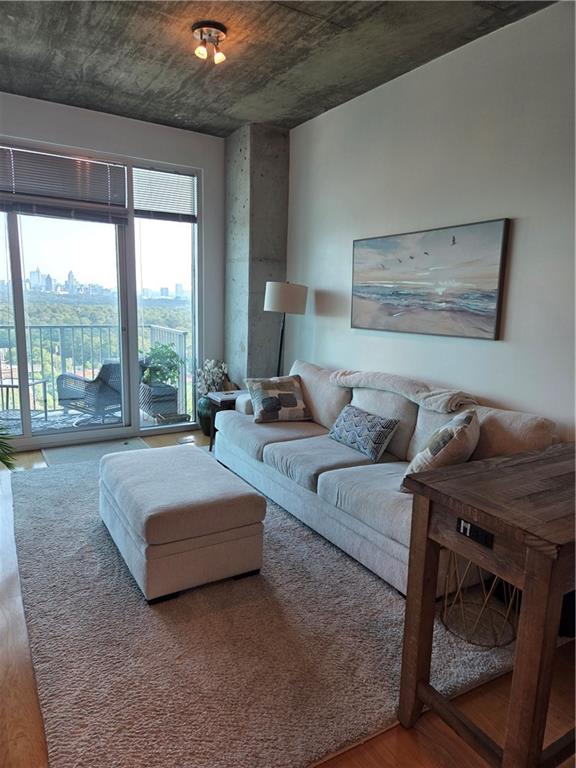 250 Pharr Road Northeast, Unit 1816 Atlanta, GA 30305 - Photo 11 of 36 a living room with furniture and a floor to ceiling window