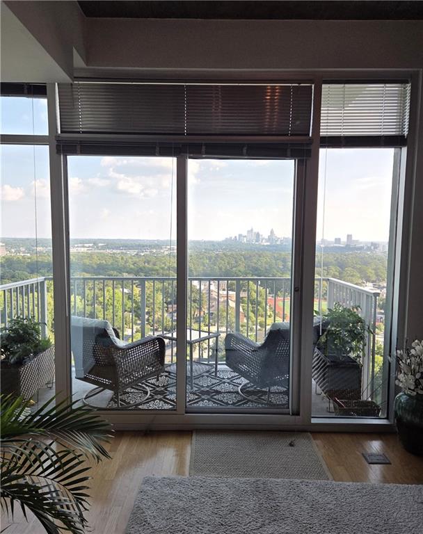 250 Pharr Road Northeast, Unit 1816 Atlanta, GA 30305 - Photo 12 of 36 a living room with hardwood floor and a floor to ceiling window