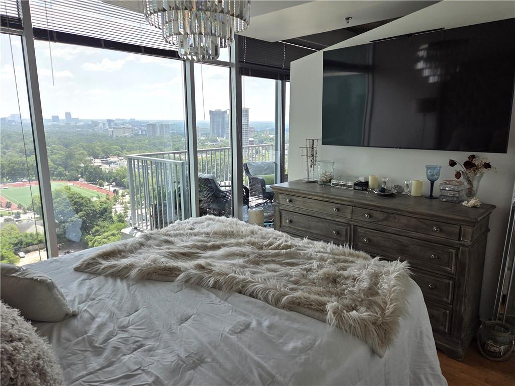 250 Pharr Road Northeast, Unit 1816 Atlanta, GA 30305 - Photo 18 of 36 a bedroom with a bed and glass window
