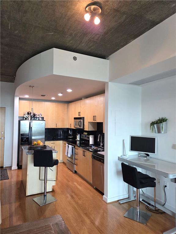 250 Pharr Road Northeast, Unit 1816 Atlanta, GA 30305 - Photo 2 of 36 a kitchen with stainless steel appliances kitchen island granite countertop a table chairs and a refrigerator