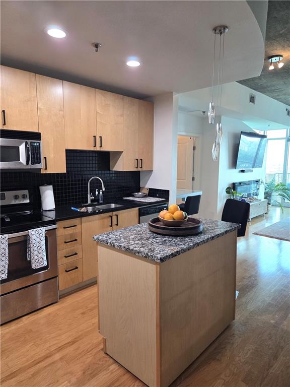 250 Pharr Road Northeast, Unit 1816 Atlanta, GA 30305 - Photo 4 of 36 a kitchen with stainless steel appliances granite countertop a sink a stove and a wooden floors