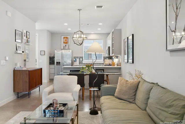 a living room with furniture kitchen and a chandelier