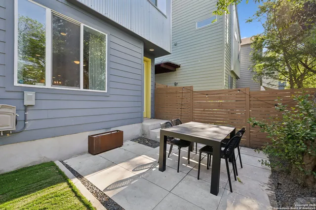 a backyard of a house with table and chairs