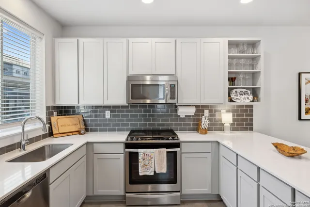 a kitchen with granite countertop white cabinets and white appliances