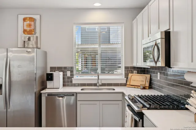 a kitchen with stainless steel appliances a sink stove and cabinets