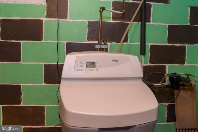 a bedroom with a bed table flowerpot and a window