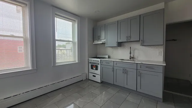 a kitchen with granite countertop white cabinets and white appliances