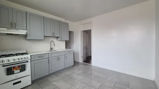 a kitchen with a stove sink and cabinets