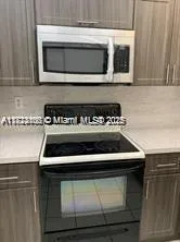 a stove top oven sitting inside of a kitchen