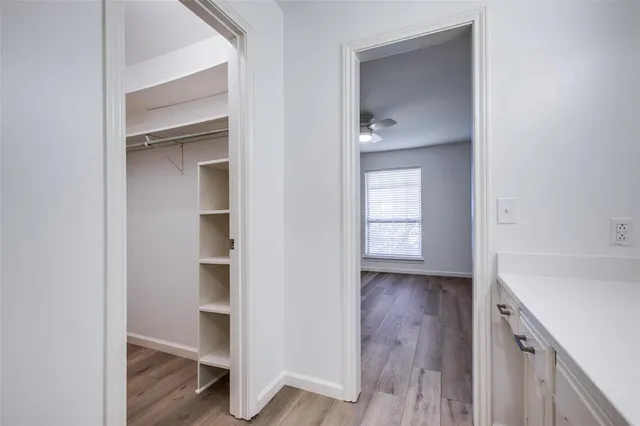 a view of an empty room with closet and a window