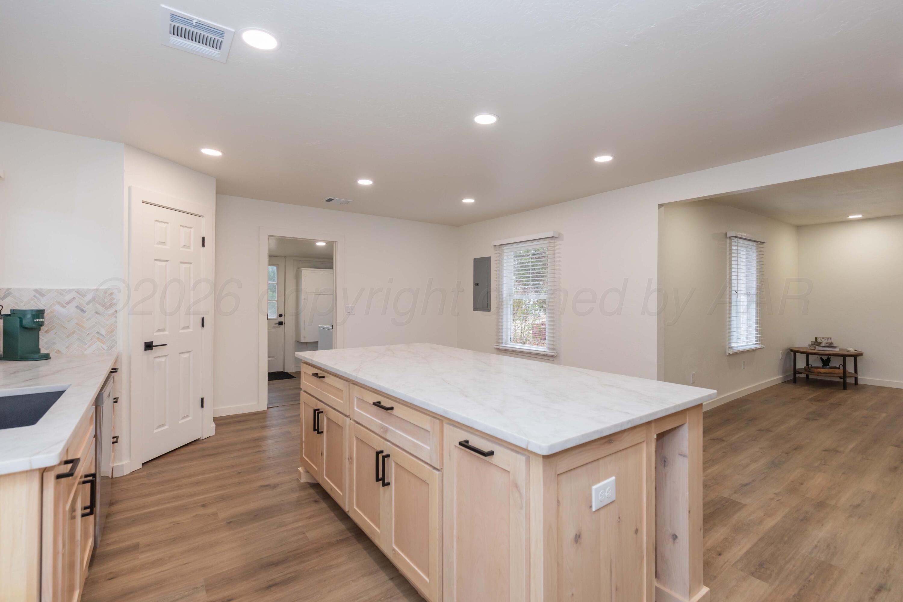 504 High Street Claude, TX 79019 - Photo 22 of 39 a view of a kitchen island a sink wooden floor with a large window