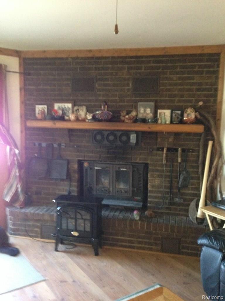 4124 North Henderson Road Davison, MI 48423 - Photo 7 of 25 Natural fireplace with wood burning insert in living room.