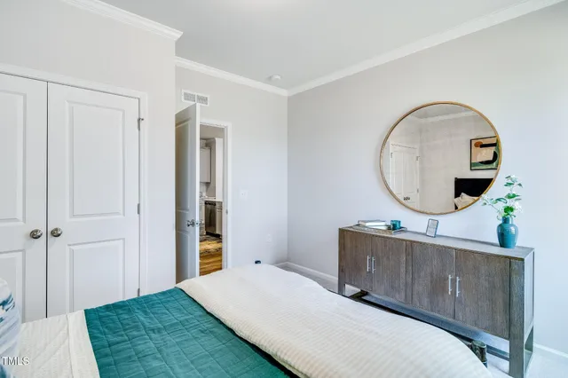 a bedroom with a bed a mirror and a table