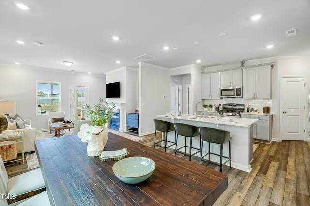 a open dining room with furniture wooden floor and kitchen view