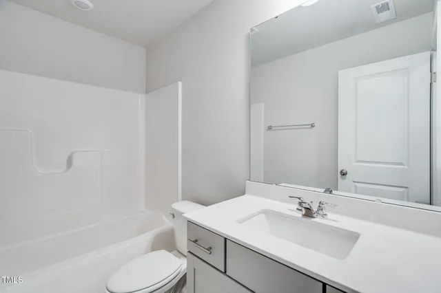 a bathroom with a sink toilet tub vanity and shower