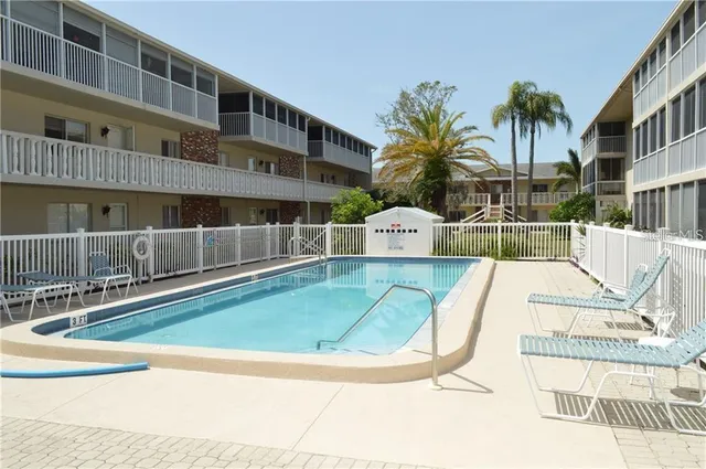 a view of swimming pool with outdoor seating and house in the back