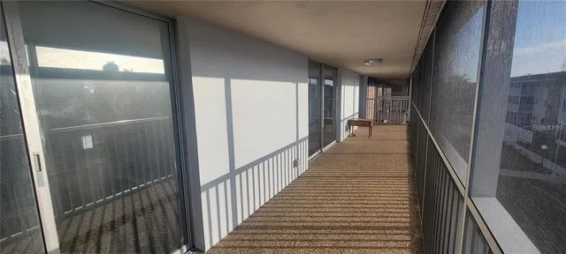 a view of a hallway with wooden floor and stairs