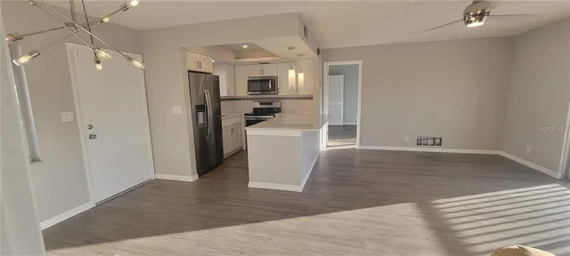 a view of a kitchen with a refrigerator and a sink